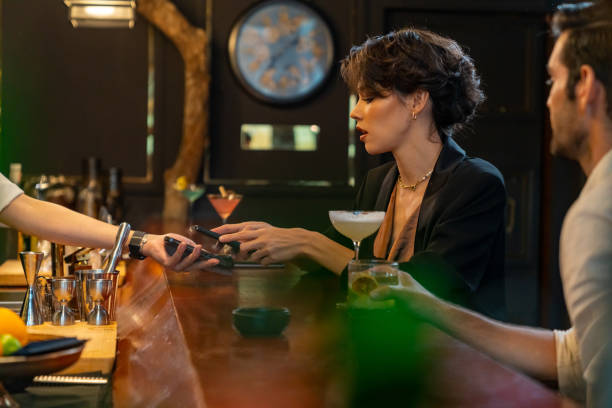 istock Caucasian woman using mobile phone making online payment scan QR code at restaurant bar 1406468122