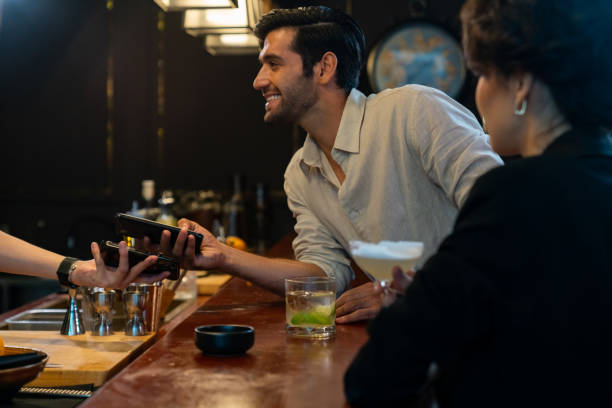 istock Caucasian man using mobile phone making online payment scan QR code at restaurant bar 1406468199