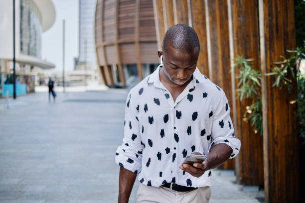 istock Businessman walking in the city using mobile phone 1406469625
