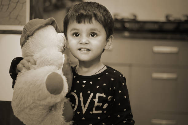 istock Baby girl playing with teddy bear 1406471313