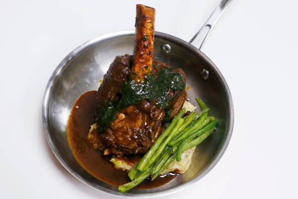 ゆっくりと調理された子羊の後のシャンクとジャガイモとインゲンを金属板に - lamb shank roast lamb leg of lamb ストックフォトと画像