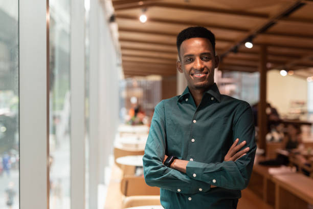 портрет красивого молодого чернокожего мужчины в кофейне - somalian culture стоковые фото и изображения