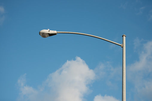 street lamp post with blue sky and white clouds