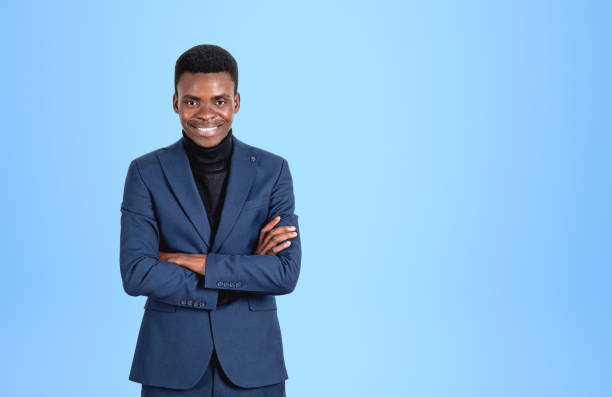 istock Black businessman with arms crossed, confident look on light blue background 1406475485