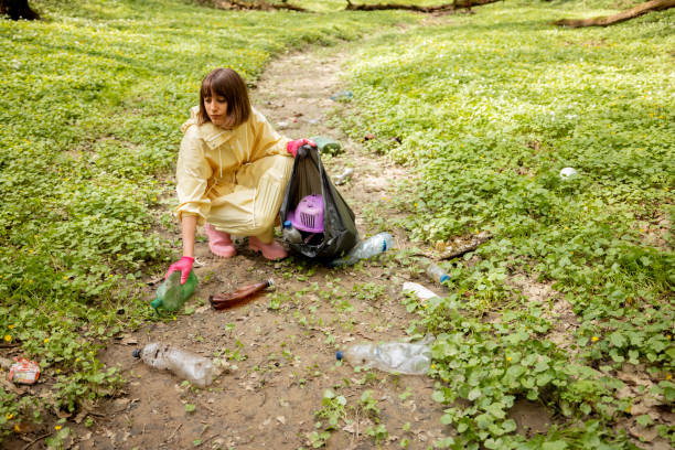 istock Woman collecting scattered plastic garbage in the woods 1406476557