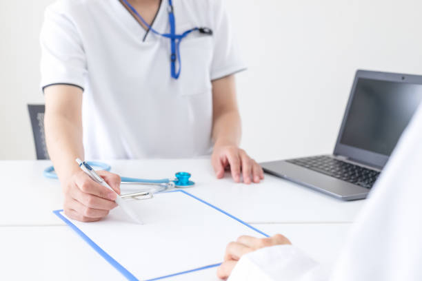 Healthcare professionals explaining how to write documents at the hospital stock photo