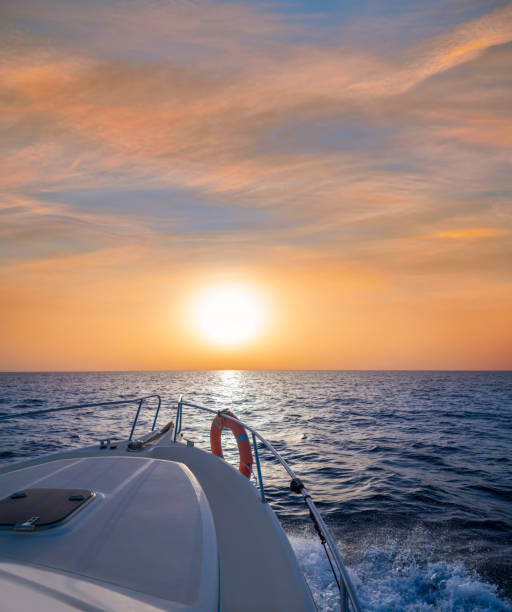 salida o puesta del sol navegando en bote en el océano mar cielo naranja y agua azul - yacht sea sunrise sailing fotografías e imágenes de stock