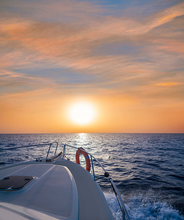 Sunrise or sunset sailing boating in the ocean sea orange sky and blue water in vacations