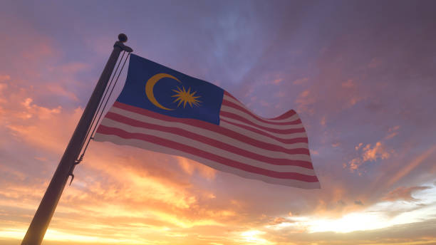 Malaysia Flag on Flagpole by Evening Sunset Sky stock photo