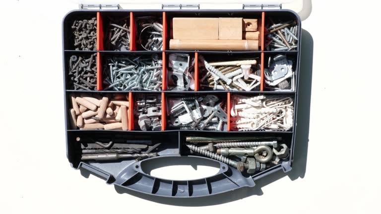 Storage box with small construction objects. Hand selects object