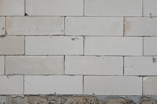 White brick block wall surface. Construction building material textured and background photo.