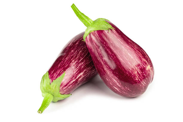 istock Purple eggplants. Fresh striped aubergines and eggplants with leaf isolated on white background. 1406485231