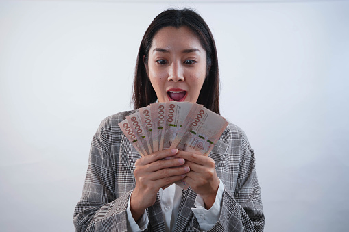 Portrait of young asian business woman showing bunch of money banknotes