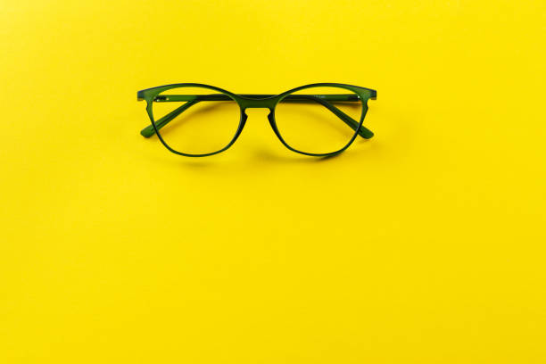 istock Stylish eyeglasses over yellow background. Optical store, glasses selection, eye test, vision examination at optician, fashion accessories concept. 1406485708