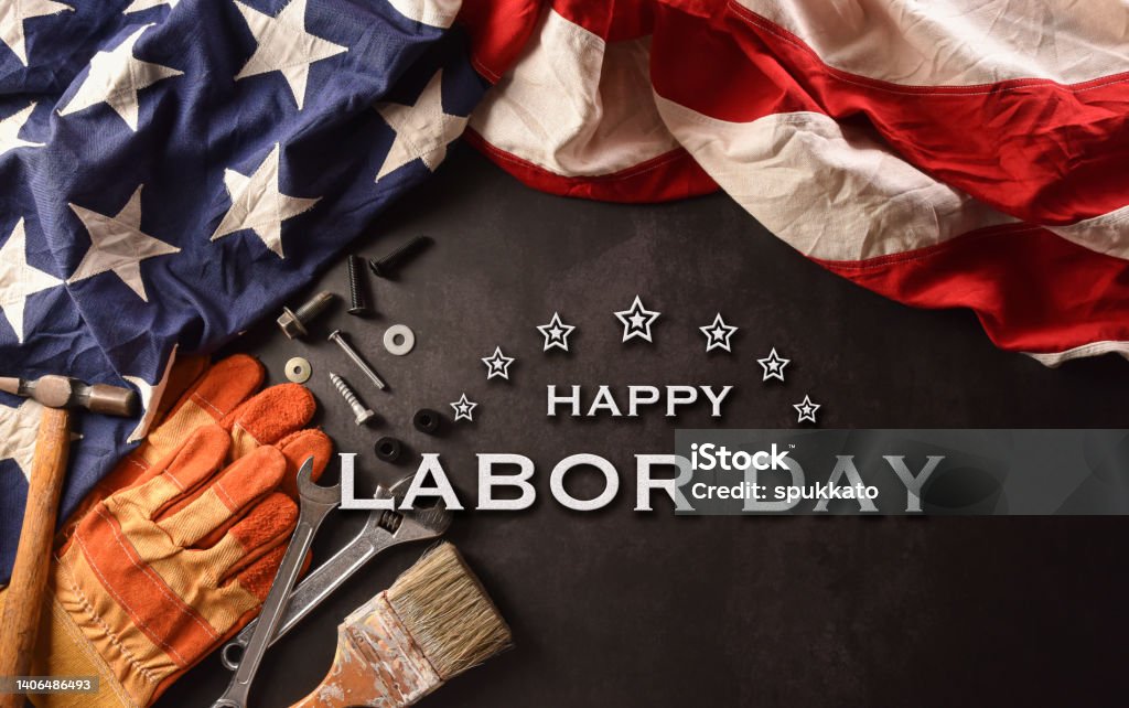 Happy Labor day concept. American flag with different construction tools and the text on dark stone background. Labor Day - North American Holiday Stock Photo