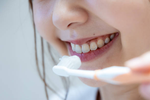 歯を磨き始めようとしている女性のクローズアップ - toothpaste ストックフォトと画像