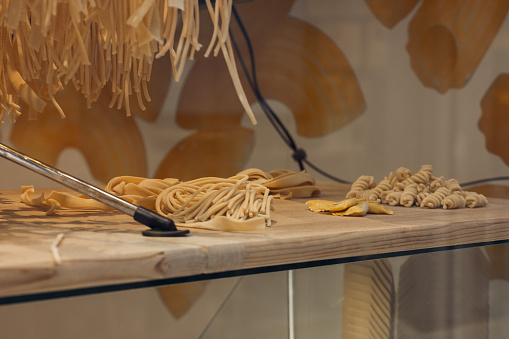 Italian pasta shop window showing fusilli, tagliatelle, ravioli and bucatini. Pasta is a staple food of Italian cuisine.
