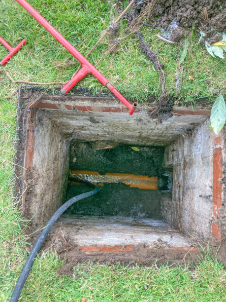 Residential inspection chamber / manhole / inspection pit with a jetting hose going into the drain attempting to unblock the sewer Residential inspection chamber / manhole / inspection pit with a jetting hose going into the drain attempting to unblock the sewer. jetting stock pictures, royalty-free photos & images