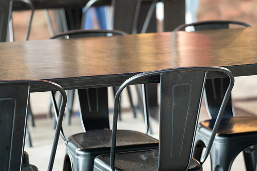 A black metallic retro style chair with counter table in restaurant. Interior furniture object photo. Close-up and selective focus.