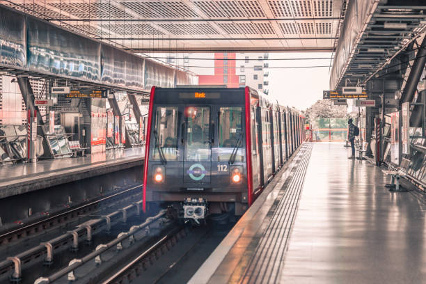 treno dlr che arriva alla stazione, nessuna piattaforma vuota. - docklands light railway foto e immagini stock