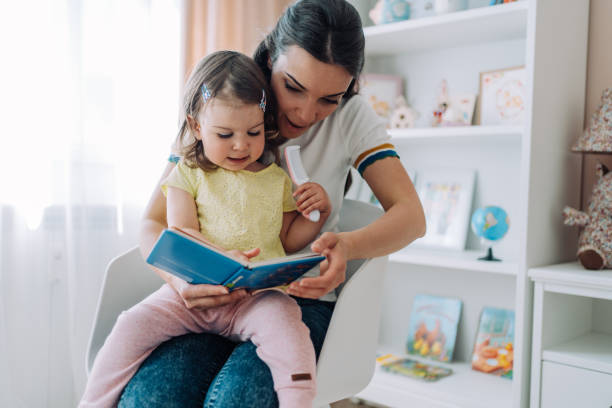 istock Mother and her little daughter reading a book. 1406495124