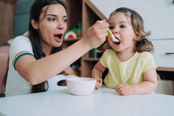 istock Mother feeding her cute little daughter. 1406495128