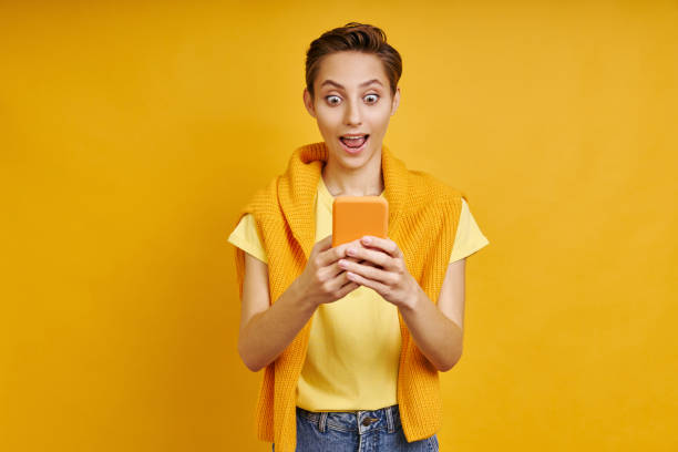 istock Surprised young woman looking at smart phone 1406496589