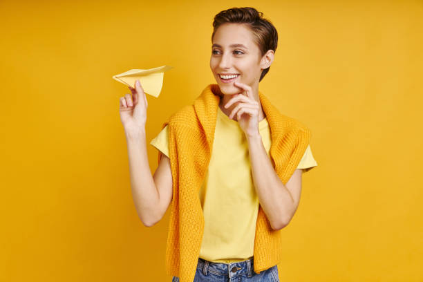 istock Thoughtful young woman holding paper airplane 1406496720