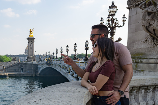 Couple in love sightseeing on the bridge of alexander III in Paris