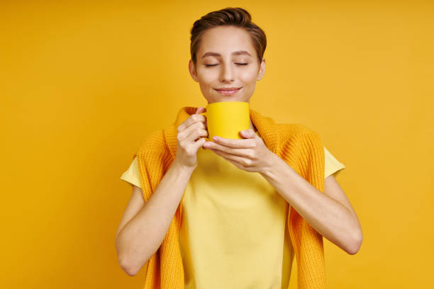 istock Joyful young woman holding cup with hot drink 1406497795