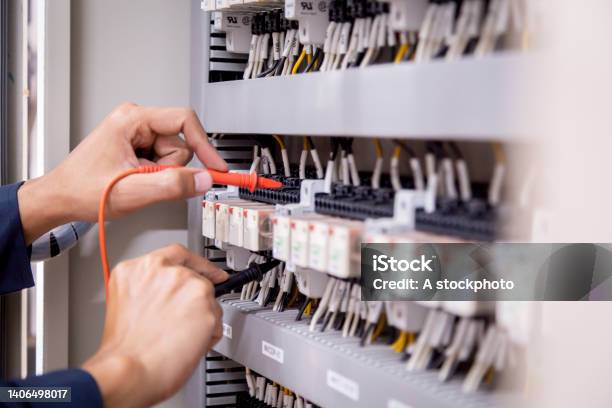 Electrical Engineer Using Measuring Equipment To Checking Electric Current Voltage At Circuit Breaker And Cable Wiring System Electrical Service Concept Stock Photo - Download Image Now