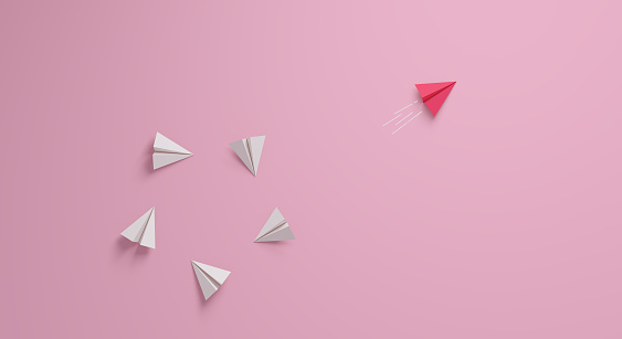 Concepto de liderazgo femenino. Individual y único líder avión de papel rosa cambiando de dirección. photo