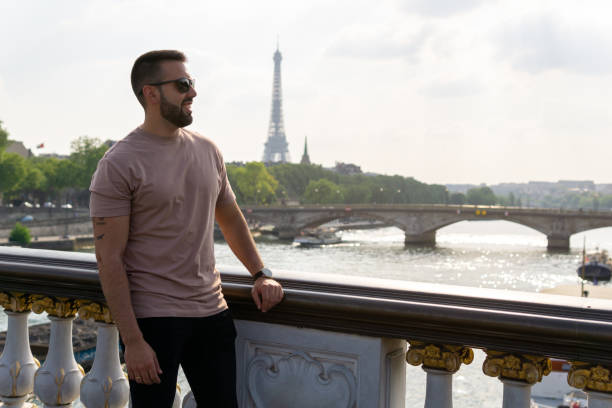 istock Happy young man with the eiffel tower and the seine river in the background 1406499994