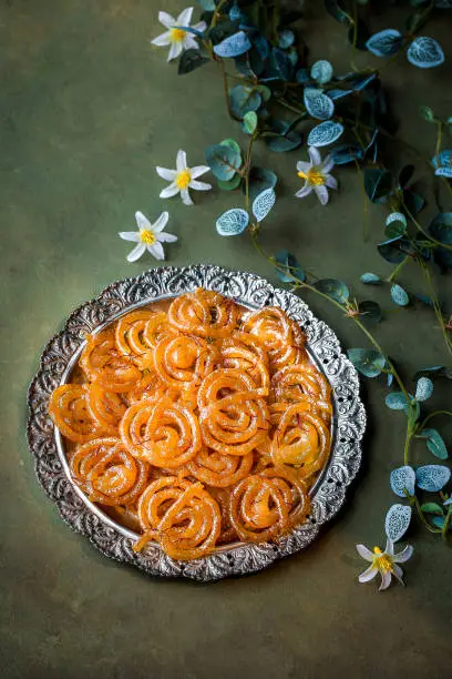 Special indian sweet jalebi or jilabi, jeelebi, and jilapi served in dish isolated on dark background top view