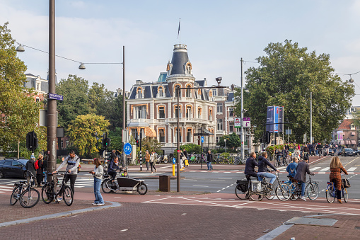 Amsterdam, The Netherlands, October 10, 2021; Cyclists and pedestrians at a busy intersection in the center of the city of Amsterdam.