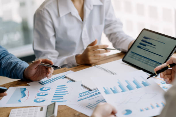 istock Business people discuss investment project working and planning strategy on digital tablet. Business people talking together with tablet at office. 1406506314