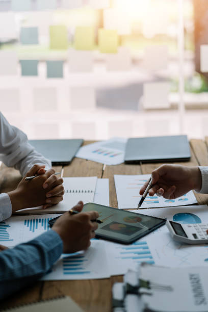 istock Business people discuss investment project working and planning strategy on digital tablet. Business people talking together with tablet at office. 1406506321
