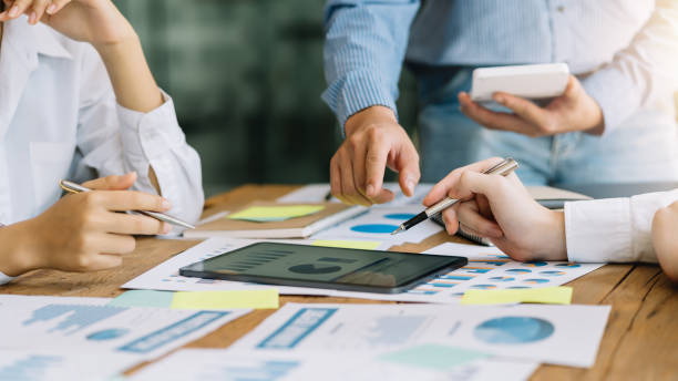 istock Business people discuss investment project working and planning strategy on digital tablet. Business people talking together with tablet at office. 1406506337