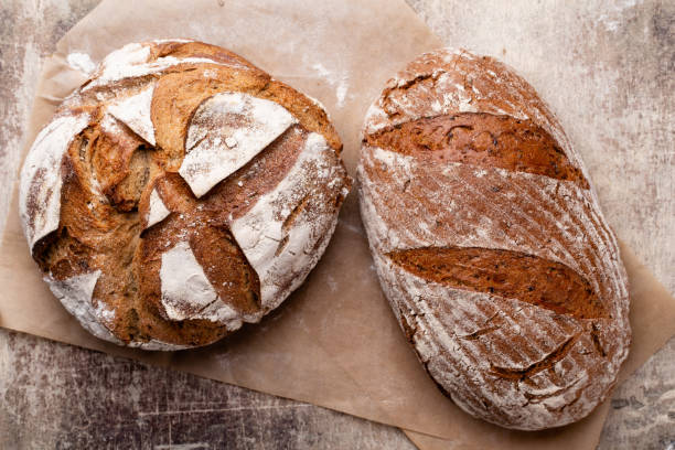 istock Assortment of baked bread on wooden table background. 1406507589