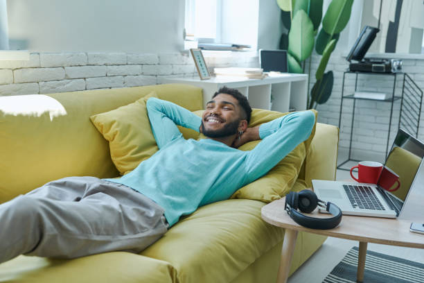 istock Happy African man holding hand behind head 1406509007