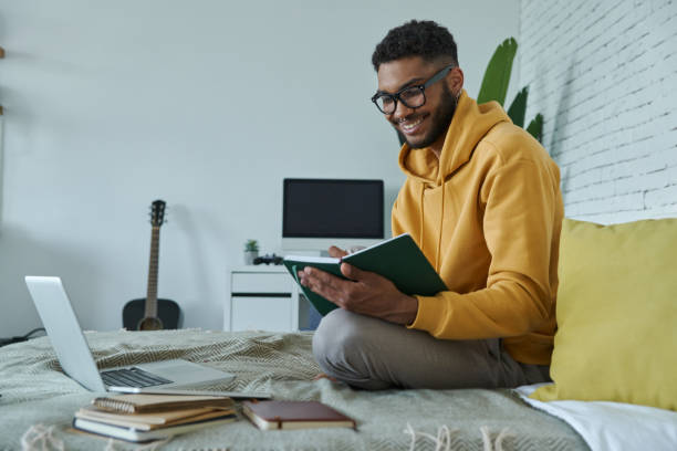 istock Confident African man writing in note pad and smiling 1406509126