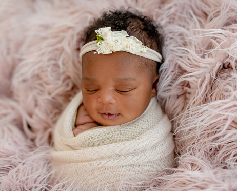 Sleeping African newborn baby girl with diadem