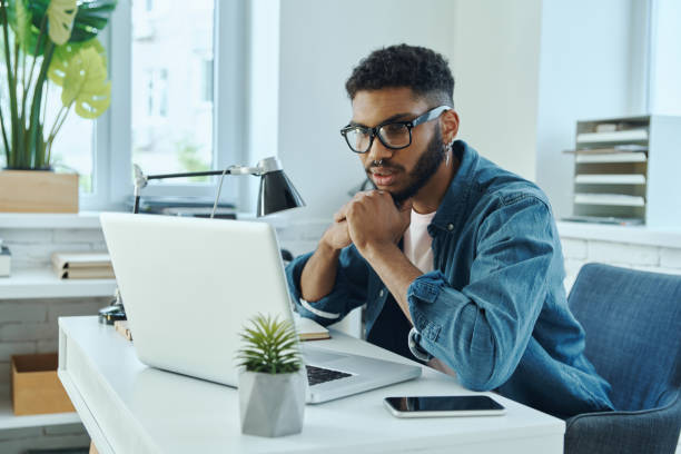 istock Concentrated young African man looking at laptop 1406510756