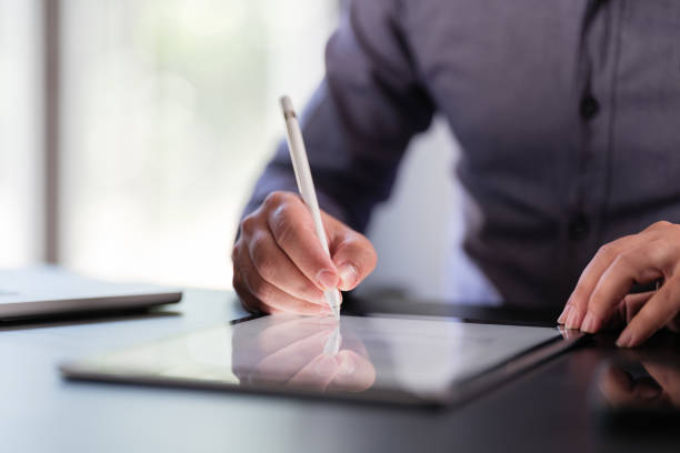 un homme d’affaires signe un contrat numérique sur tablette - pen contract writing signature photos et images de collection