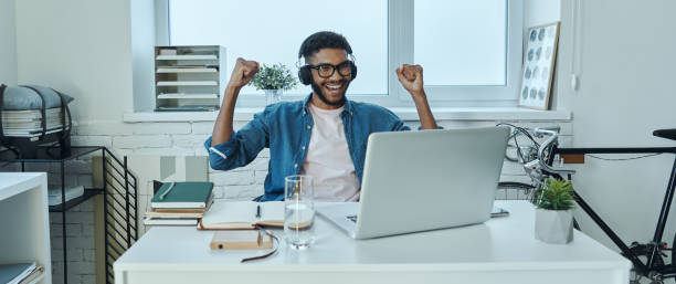 istock Excited young African man in headphones gesturing 1406511563