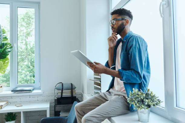 istock Thoughtful African man holding digital tablet 1406511714