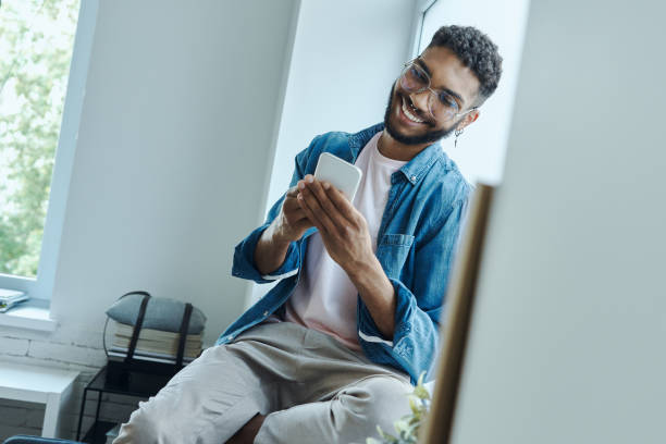 istock Cheerful African man using smart phone 1406511826