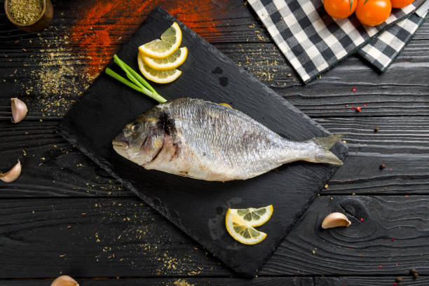 istock Steamed dorado on dark stone plate top view 1406512621