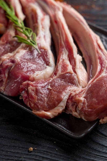 istock raw lamb on dark plate, rack of lamb, vertical, macro close up 1406512863