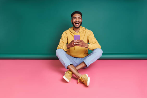 istock Excited African man holding smart phone 1406512876